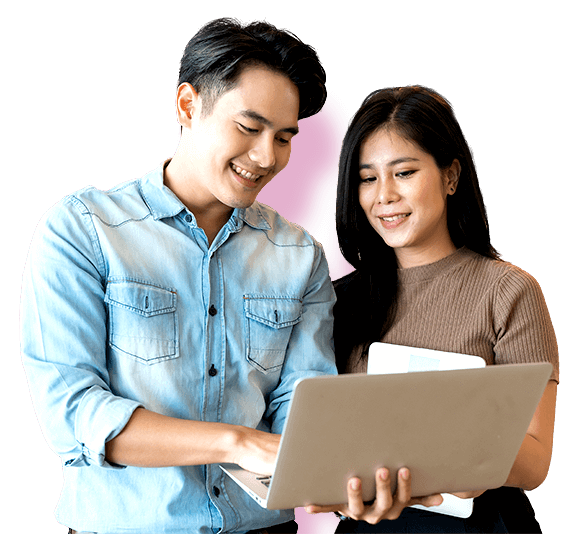 Two people looking at a laptop screen together, with the man pointing at the screen while the woman holds documents.